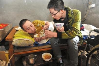 17歲男孩為照顧癱瘓父親 背著爸爸上學(xué)